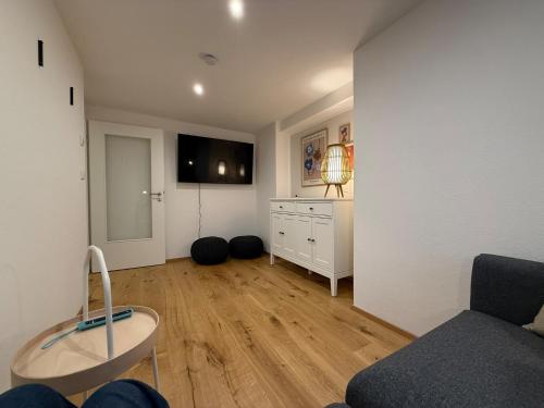 a living room with a couch and a tv on a wall at Ferienwohnung "Beim Xander" in Altenstadt