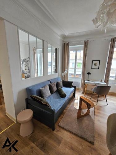 un salon avec un canapé bleu et une table dans l'établissement L 'Élégant - Calme - proche des Halles de Pau, à Pau