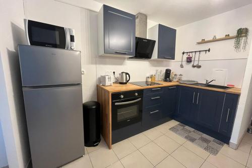 une cuisine avec un réfrigérateur en acier inoxydable et un comptoir dans l'établissement L'Aycelin - Appartement proche des Halles Wifi, à Narbonne