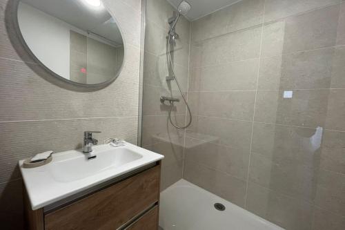 une salle de bain avec un lavabo, une douche et un miroir dans l'établissement L'Aycelin - Appartement proche des Halles Wifi, à Narbonne