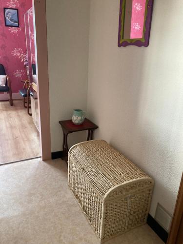 un pouf en osier assis dans un coin de pièce dans l'établissement Location cure thermale, à Vittel