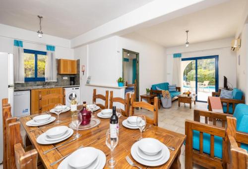a kitchen and living room with a wooden table and chairs at Azzurro Holiday Villas in Peyia