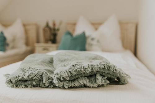 a blanket sitting on top of a bed at Neidhardt Vendégház in Bóly