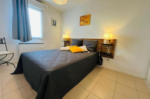 - une chambre avec un lit doté d'un oreiller jaune dans l'établissement Le Rimini Terrasse Wifi Parking privé, à Narbonne