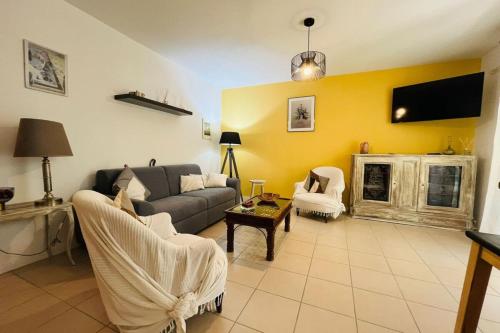 un salon avec un canapé et une télévision dans l'établissement Le Rimini Terrasse Wifi Parking privé, à Narbonne