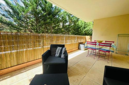 d'une terrasse avec des chaises, des tables et une clôture. dans l'établissement Le Rimini Terrasse Wifi Parking privé, à Narbonne