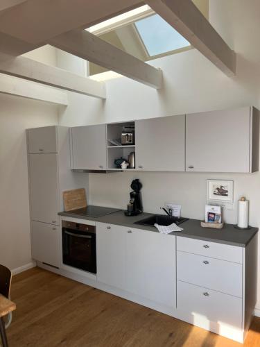a kitchen with white cabinets and a black counter top at Ostsee-Strandhaus-Holnis in Glücksburg