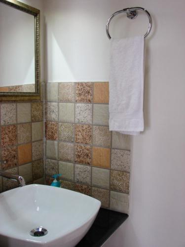 a bathroom with a sink and a mirror and a towel at Abad Premium House Boat in Kumarakom