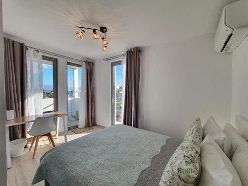 a bedroom with a bed and a desk and windows at Hi Hellas 4 in Artemida