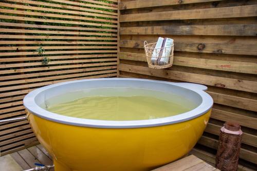 a large yellow tub sitting next to a wooden wall at The Cacoon Tsitsikamma in Stormsriviermond