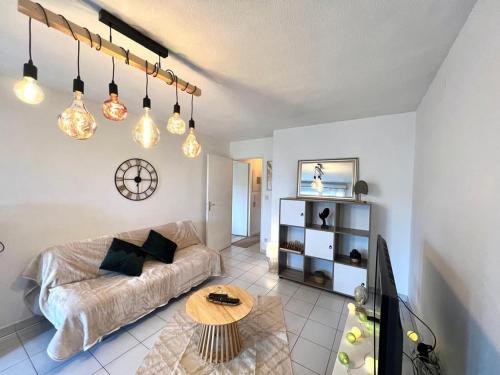 a living room with a couch and a table at Le Montaigne - Parking inclus, Tramway et MEET in Blagnac