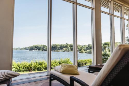 a room with large windows looking out at the water at Vitalia Seehotel in Bad Segeberg