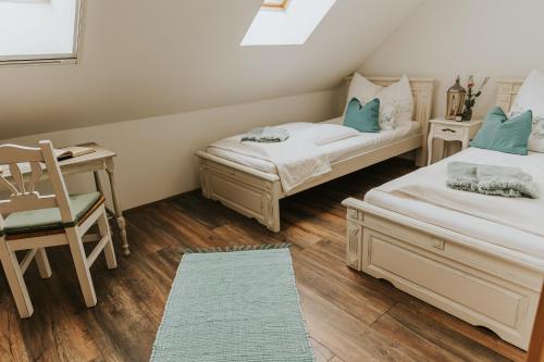 two beds in a room with a desk and a chair at Neidhardt Vendégház in Bóly