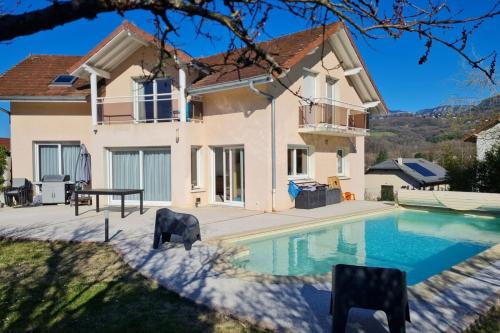 une villa avec piscine devant une maison dans l'établissement Maison Familiale avec piscine, à Aix-les-Bains