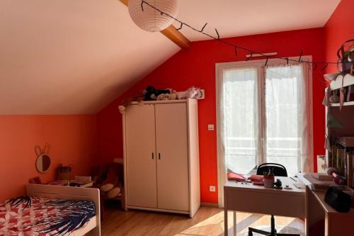 - une chambre avec des murs rouges et une armoire blanche dans l'établissement Maison Familiale avec piscine, à Aix-les-Bains