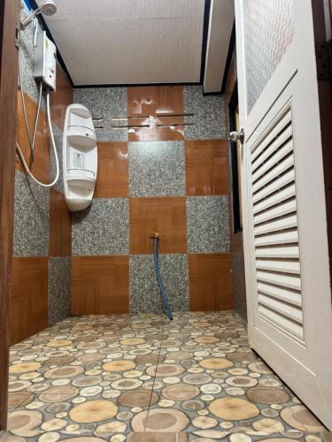 a bathroom with a shower with a tile floor at Archary Lanta Apartment in Ko Lanta