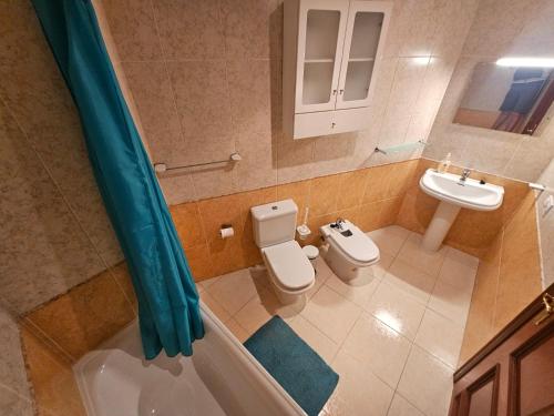 łazienka z wanną, toaletą i umywalką w obiekcie Amazing ocean view apartment w Corralejo