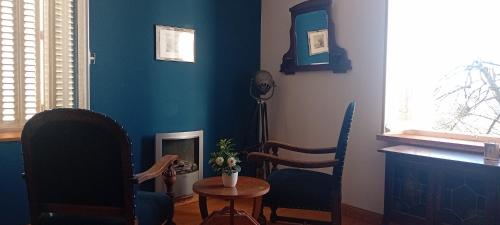 a living room with blue walls and a table and chairs at Chambres et table d'hôte Rabillou in Saint-Moreil