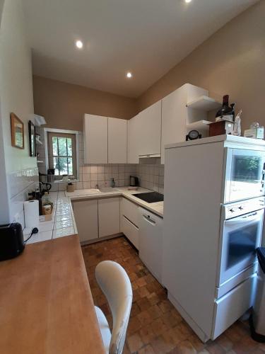 une cuisine avec des armoires blanches et une table et des chaises dans l'établissement Demeure de caractère et son parc 12pers, à Meunet-sur-Vatan