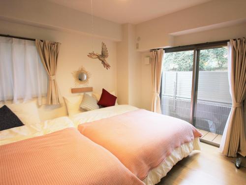 a bedroom with a large bed and a window at Alphabed広島平和大通り in Hiroshima