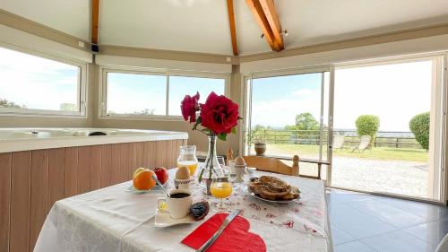 une table avec un vase de fleurs et de fruits sur elle dans l'établissement Loft avec jacuzzi et sauna, à Ferrières-la-Verrerie