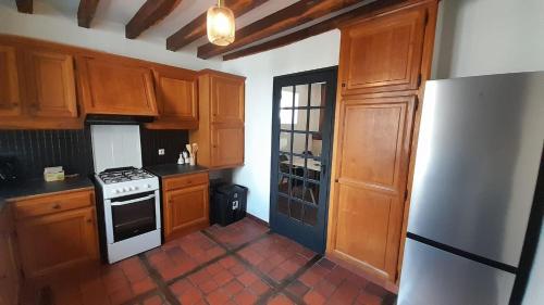 a kitchen with wooden cabinets and a white stove top oven at Appart central Vatan-2 chb- wifi in Vatan