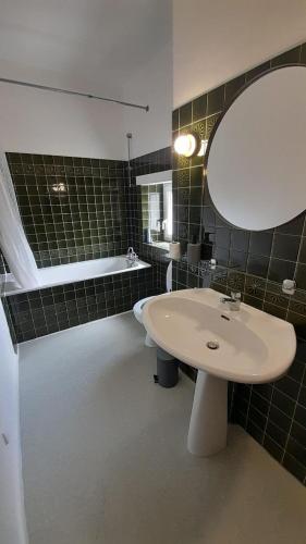 une salle de bain avec un lavabo, un miroir et une baignoire dans l'établissement Appart central Vatan-2 chb- wifi, à Vatan