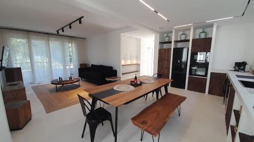 Il dispose d'une cuisine et d'un salon avec une table et des chaises en bois. dans l'établissement Superbe maison 3 chb-clim-jardin, à Châteauroux