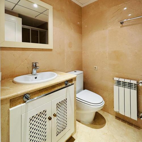 a bathroom with a toilet and a sink and a mirror at Casa Ingram by SunshineClub in Roda