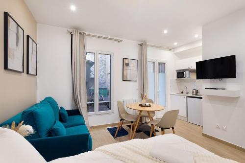 un salon avec un canapé bleu et une table dans l'établissement Lasuite Montbrun, à Paris