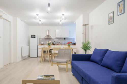 un salon avec un canapé bleu et une cuisine dans l'établissement La Suite du Château B - En plein centre, à Lunéville