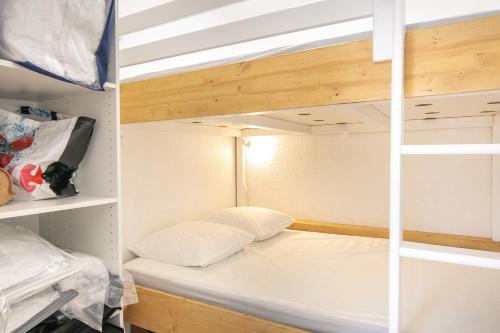een stapelbed met een wit kussen in een kamer bij Le Murmure des Flocons - Vostok Zodiaque in Villarembert