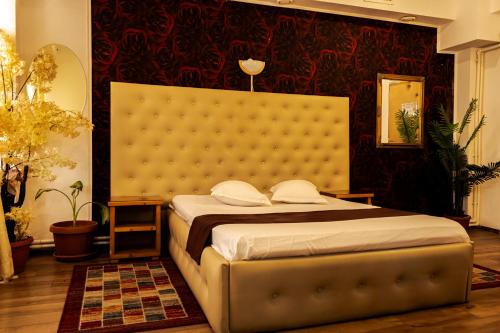 a bedroom with a bed with a large headboard at Hotel Funnytime in Bucharest