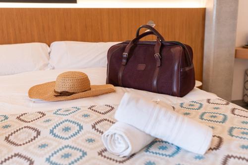 a hat and a bag sitting on a bed at Finca Agroturismo Son Menut in Felanitx