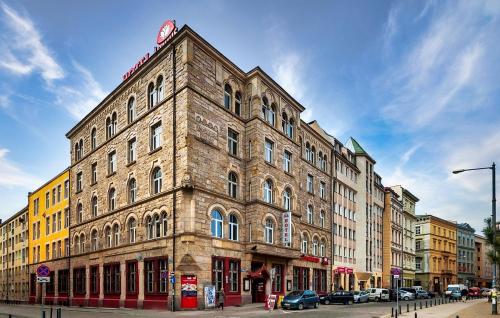 a large brick building on the corner of a street at Hotel Lothus in Wrocław