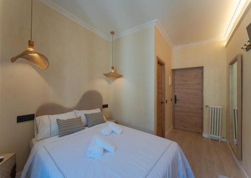 a bedroom with a white bed with two towels on it at Das Carretas in Madrid