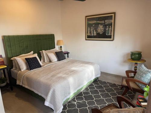 a bedroom with a large bed with a green headboard at Villa ArthurCC in Hikkaduwa