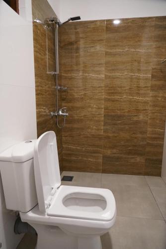 a white toilet in a bathroom with a shower at Hiri Point Villa in Dickwella