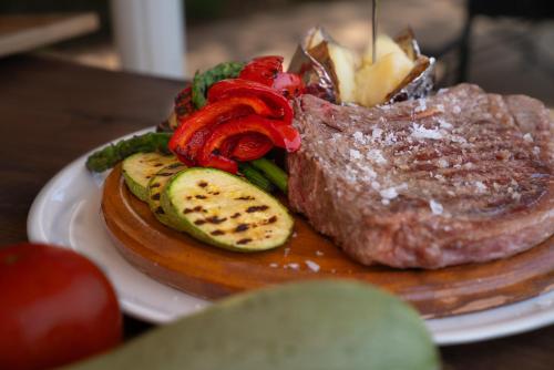 a piece of steak with vegetables on a plate at Finca Agroturismo Son Menut in Felanitx