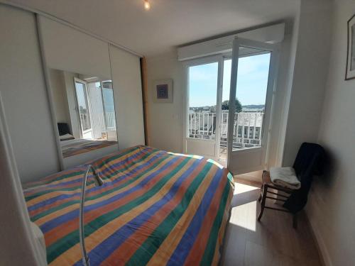 une chambre avec un lit et une grande fenêtre dans l'établissement T3 hyper centre- ascenseur- parking- balcon, à Châteauroux