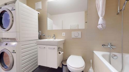 y baño con aseo, lavabo y lavadora. en 2BR flat in the city center - West 12, en Zúrich