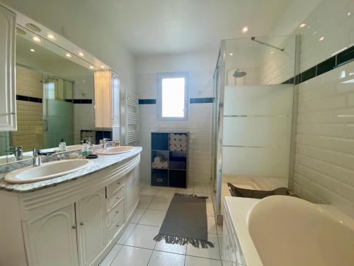 une salle de bain avec deux lavabos, une baignoire et une douche dans l'établissement Maison 3 chb-billard-wifi-jardin-canoë, à Buzançais