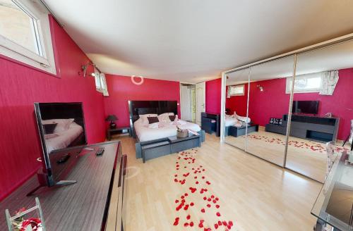 a room with two beds and red walls with red petals on the floor at Loft avec jacuzzi et sauna in Ferrières-la-Verrerie