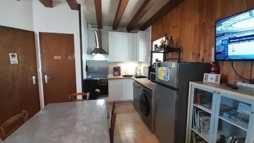 a kitchen with a stainless steel refrigerator and a table at La maison de l'étang in Saint-Georges-sur-Arnon