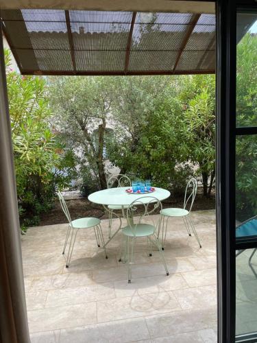 une table et des chaises assises sur une terrasse dans l'établissement Maison Kokopetit - Dans les Corbières, à Saint-Laurent-de-la-Cabrerisse