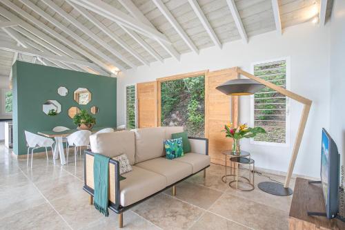 a living room with a couch and a table at Villas Tangarane in Les Trois-Îlets