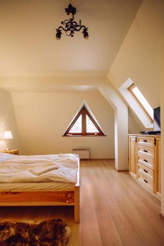 an attic bedroom with a bed and a window at Słoneczny Pacyfik in Kościelisko