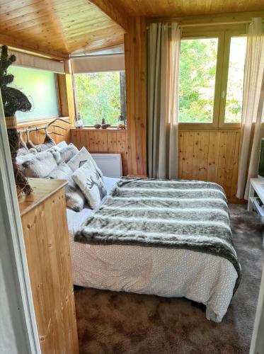 une chambre avec un lit dans une pièce avec des fenêtres dans l'établissement Chalet chaleureux à Courchevel avec vue sur la montagne, à Courchevel