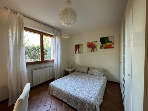 Un dormitorio con una cama y una ventana en Relais Madama Dorè, en Scandicci