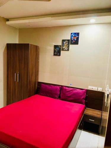a bedroom with a bed with a red blanket at Meridin Regency in Ernakulam
